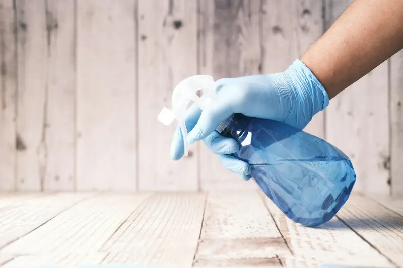 Gloved hand holding a cleaning spray bottle D&A Cleaning Ltd