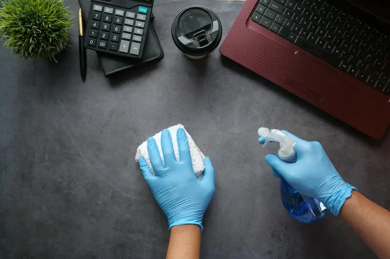 Gloved hands sanitising an office desk during commercial cleaning D&A Cleaning Ltd