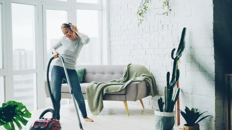 Cleaner vacuuming a bright living room during a regular domestic clean D&A Cleaning Ltd Ilford