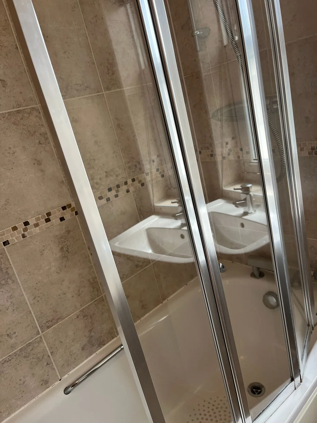 Bath shower doors clear over mosaic tiles