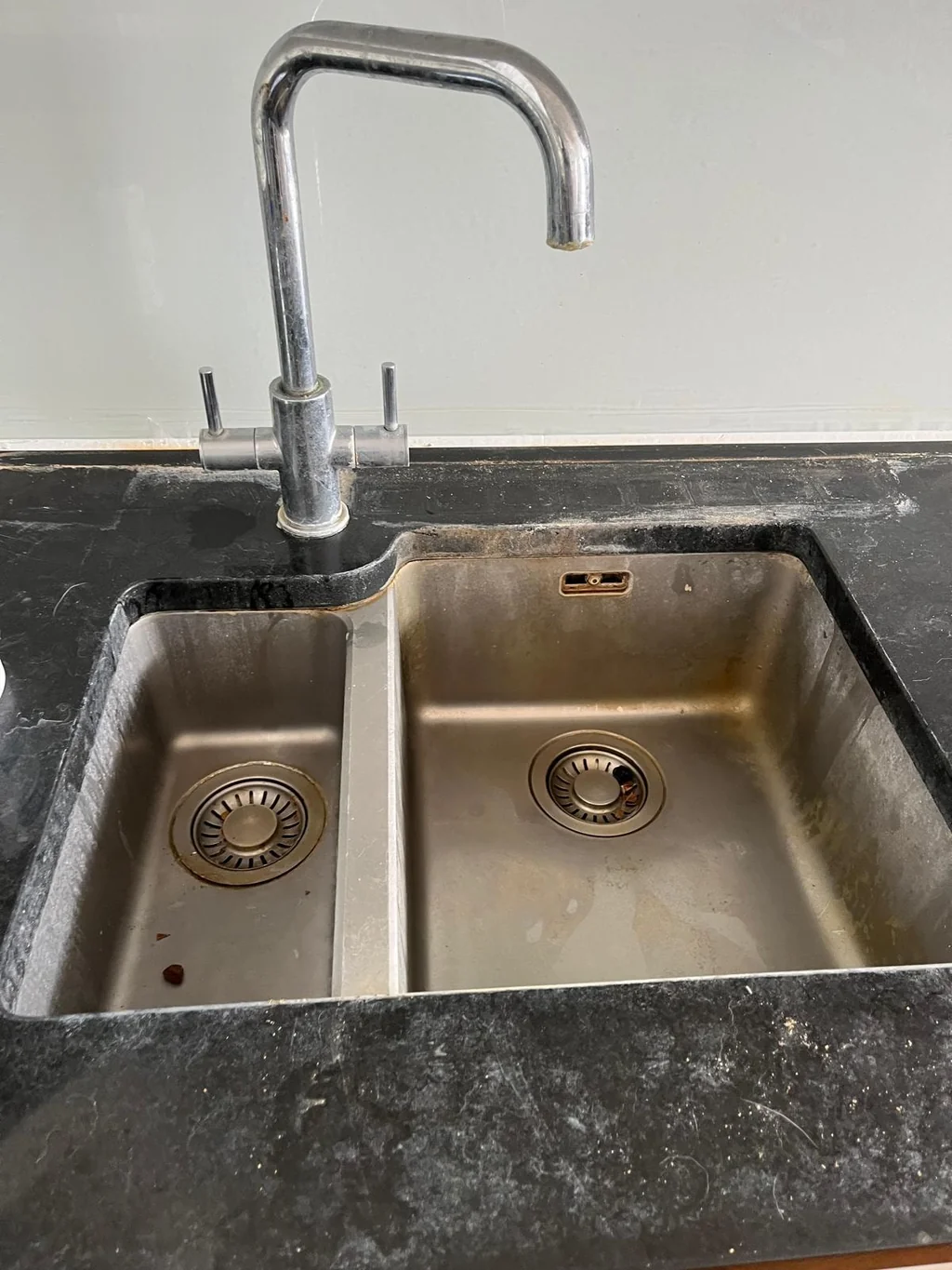Stainless steel double sink dull with grease and watermarks before cleaning