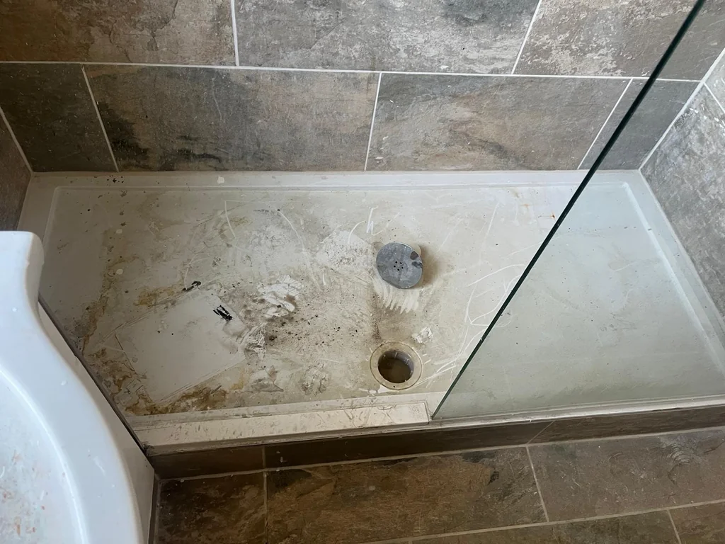Shower tray stained with limescale before descaling
