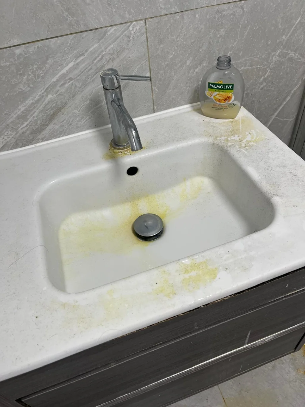 Vanity basin stained with limescale and grime before cleaning
